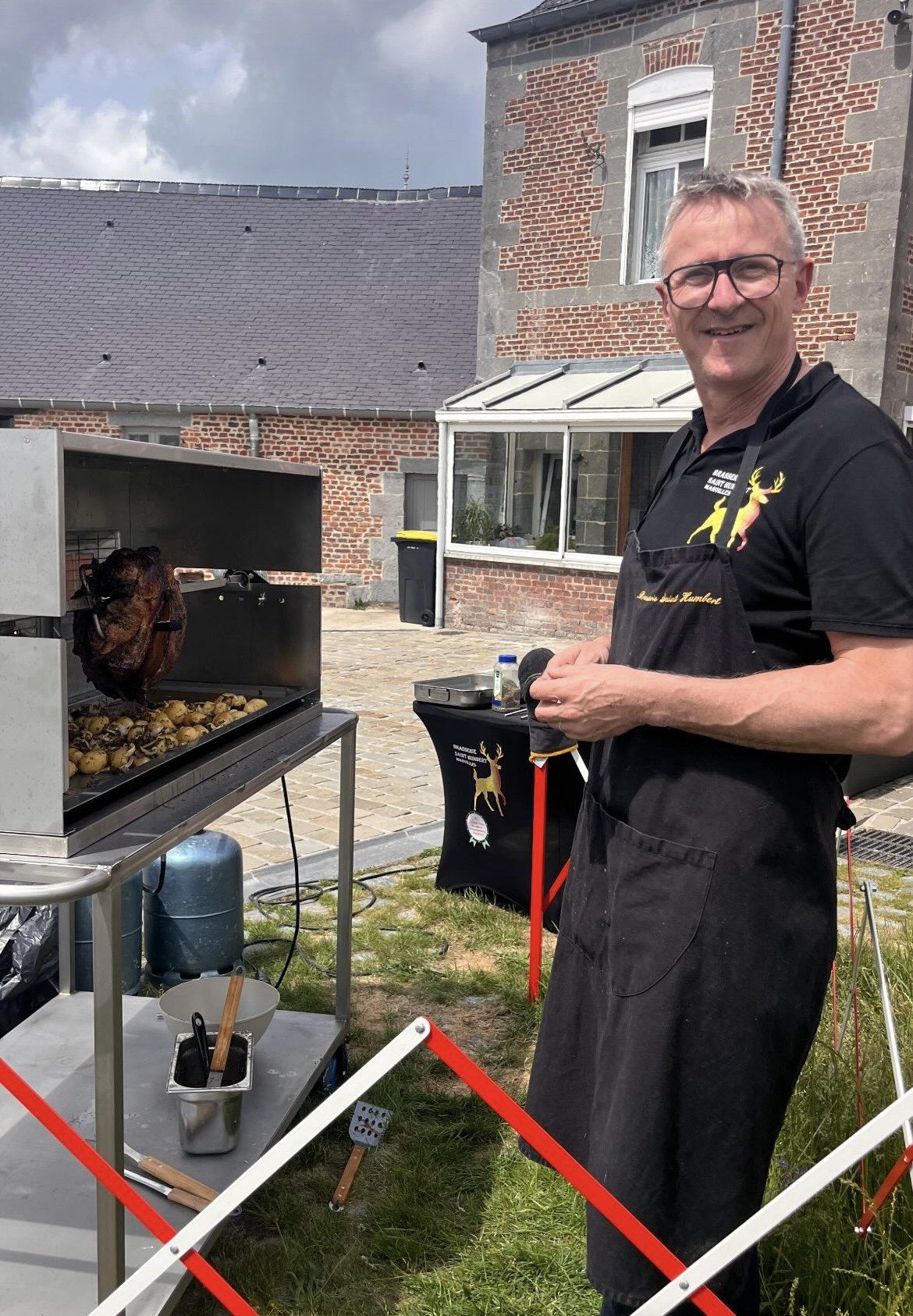 Le brasseur devant la rôtissoire du jambon à la broche