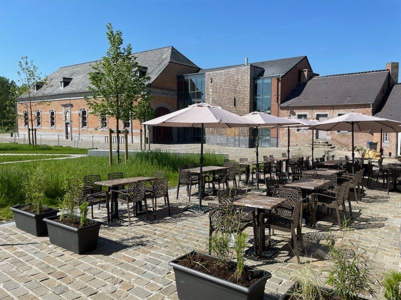 Terrasse de la brasserie dans la cour de l’abbaye de Maroilles, parasols ouverts